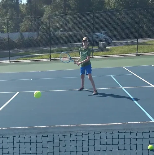 My son playing tennis for his first time